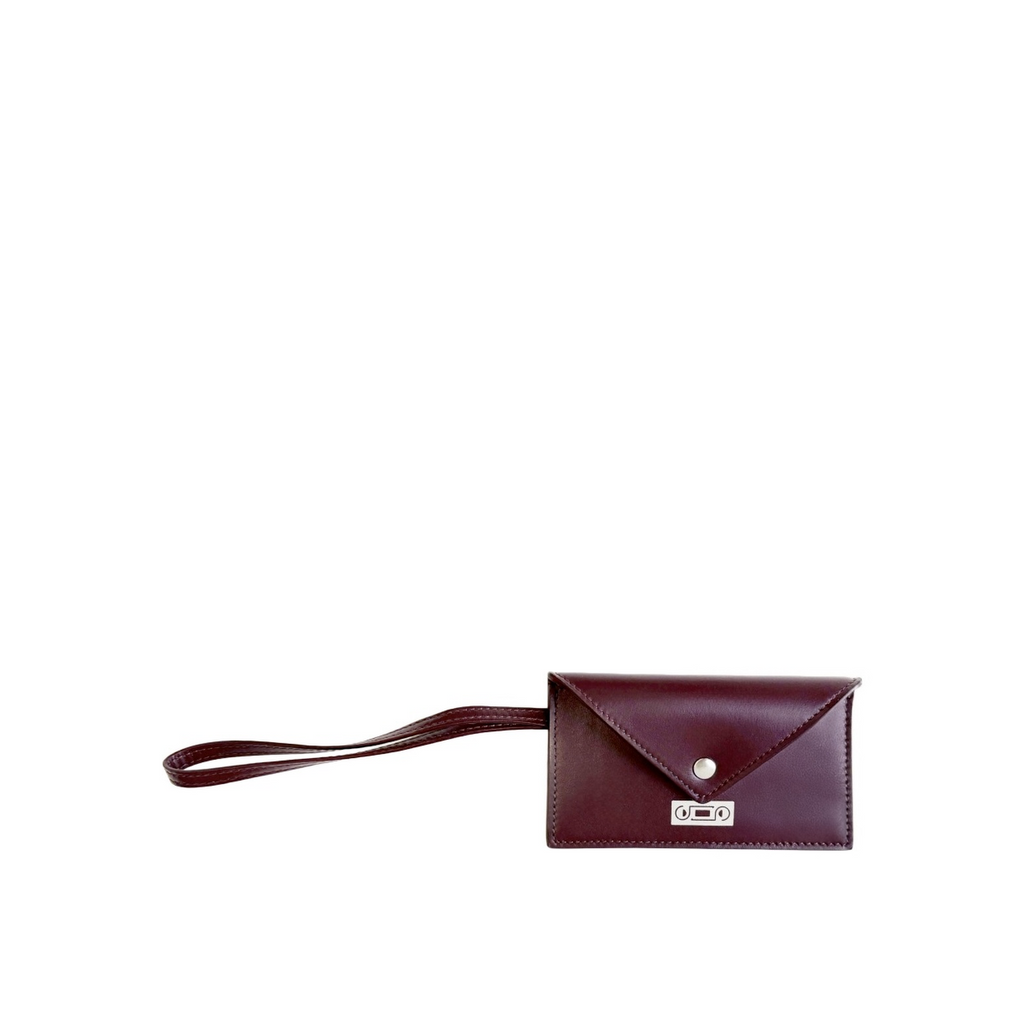 The Business Card Holder by Studio Tondini in refined burgundy leather, featuring a silver foil logo stamp and a practical wrist strap, handcrafted in Italy.