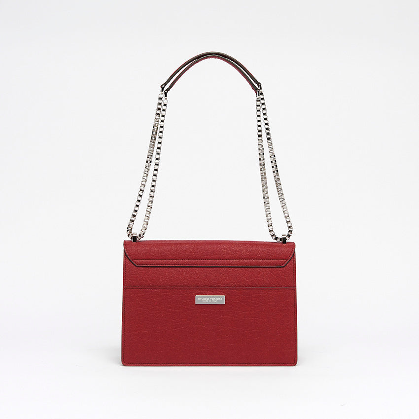 The Cristiana Vegan Shoulder Bag by Studio Tondini. Back view of the cherry red version, showcasing clean architectural lines, a rear pocket, and the discreet branded plate.