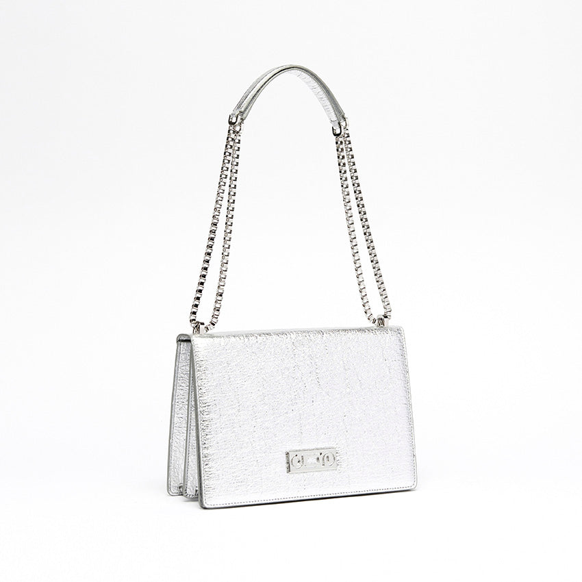 The Cristiana Vegan Shoulder Bag by Studio Tondini. Three-quarter view of the silver version, highlighting the radiant chain plated in real palladium and the sculptural structure crafted from Piñatex®.