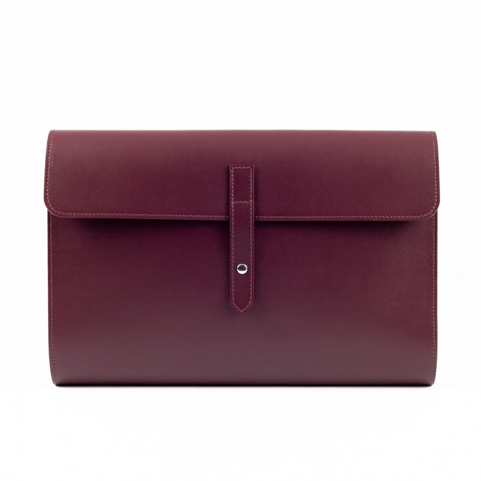 The Document Holder by Studio Tondini. Front view of burgundy Italian leather bag with button closure, showcasing clean lines and fine craftsmanship.